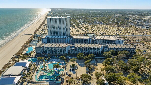 A coastal hotel with a large building, a pool area, and a beach view. - MB Ocean Spa 526-Ocean view, Great Amenities (Myrtle Beach)