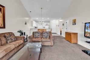 Ein Wohnzimmer mit einer Couch, einem Couchtisch und einem Fernseher.