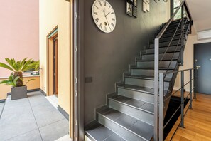 Eine Treppe mit einer Uhr, einem Topfpflanzen und einer Tür.