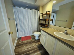 Un bagno con servizi igienici, lavandino e tenda da doccia.