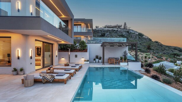 A modern house with a swimming pool, outdoor seating, and a view of a hill. - Olea Hill Villas - Luxury Villa Lamina, by Estia (Vathianos Kampos)
