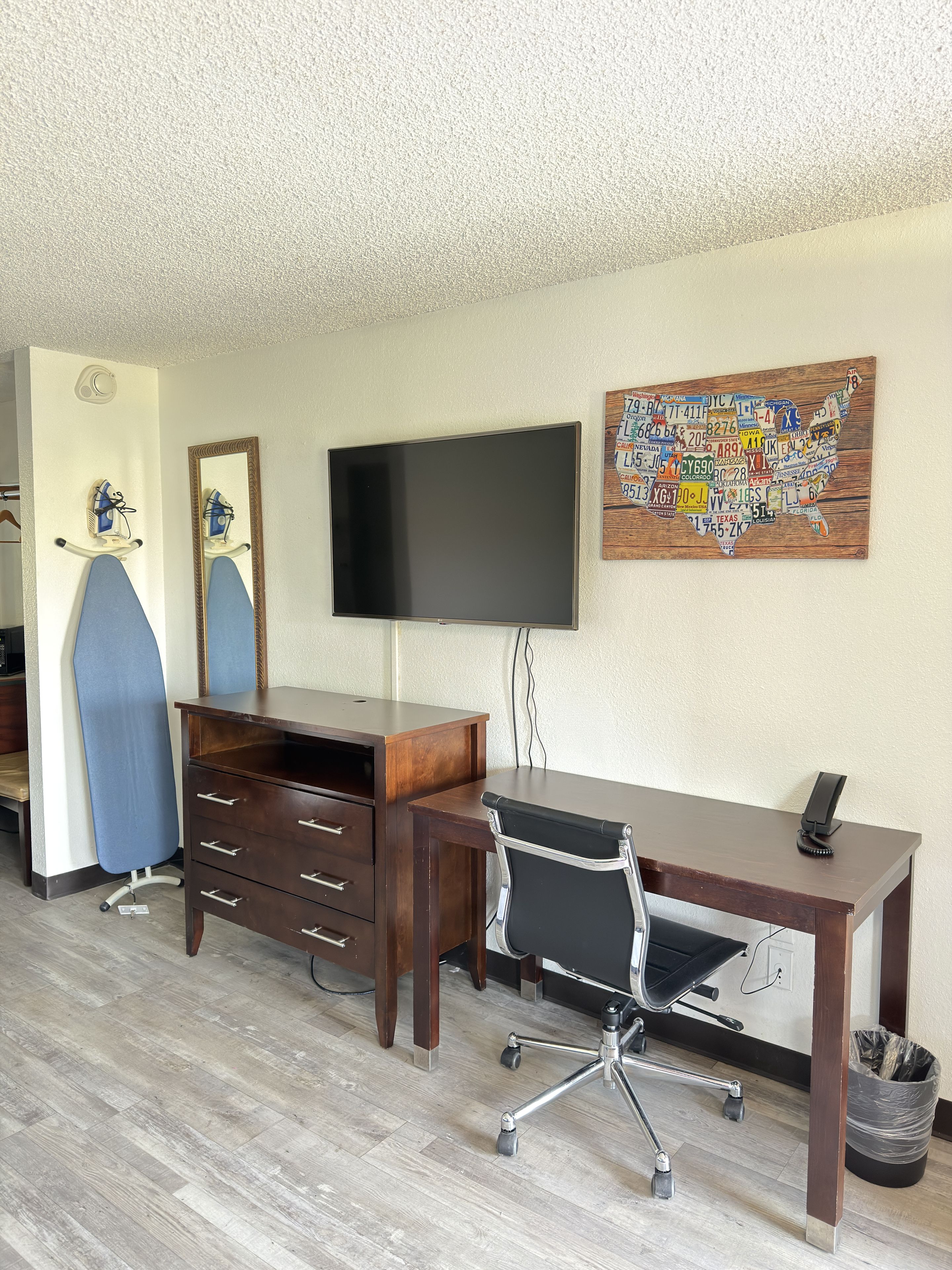 Una habitación con escritorio, silla, televisor y un mapa de los Estados Unidos en la pared.