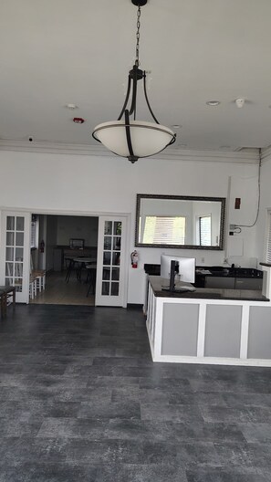 A spacious kitchen with a central island, a dining area with chairs, and a large mirror above the island.