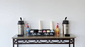 Ein Kaffeeangebot mit zwei Kaffeeautomaten, einem Kaffeeausgabegerät und einer Kaffeeflasche mit Sahne.
