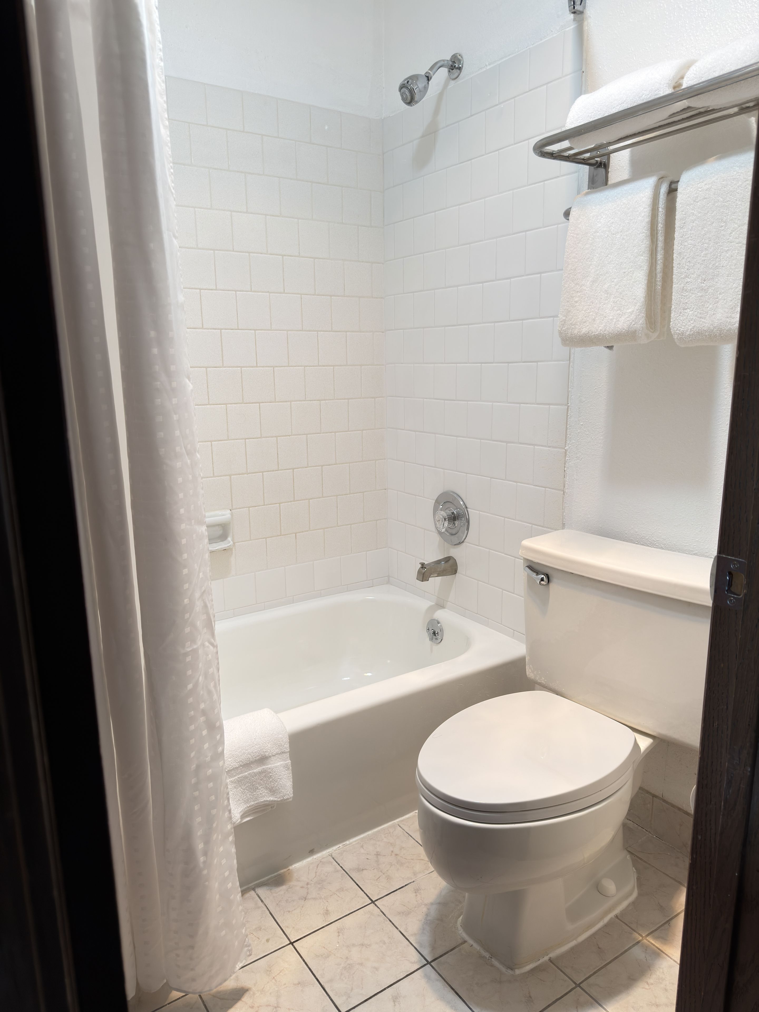 Un bagno con una vasca, un water e un portasciugamani.