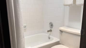 Un bagno con una vasca, un water e un portasciugamani.