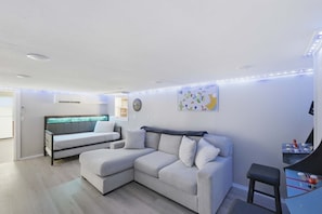 A modern living room with a sectional sofa, a small table, and a wall-mounted TV.