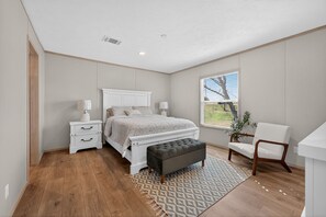 A bedroom with a bed, bedside tables, a bench, a chair, and a window. - Private Countryside Escape • Deck Views • Near SA (Adkins)