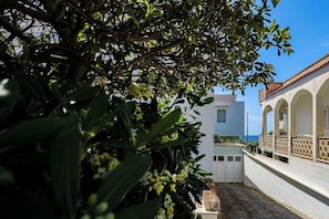 A building with a white facade, arched balconies, and a view of the sea. - Zaffiro by Casa di Marco (Torre Suda)