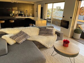 A modern living room with a grey sofa, fluffy white rug, and a round coffee table. - Magnificent 3-room apartment (Le Cannet)