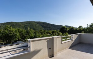 A balcony with a view of a forested hillside. - Amazing home in Muc Gornji (Muc Gornji)