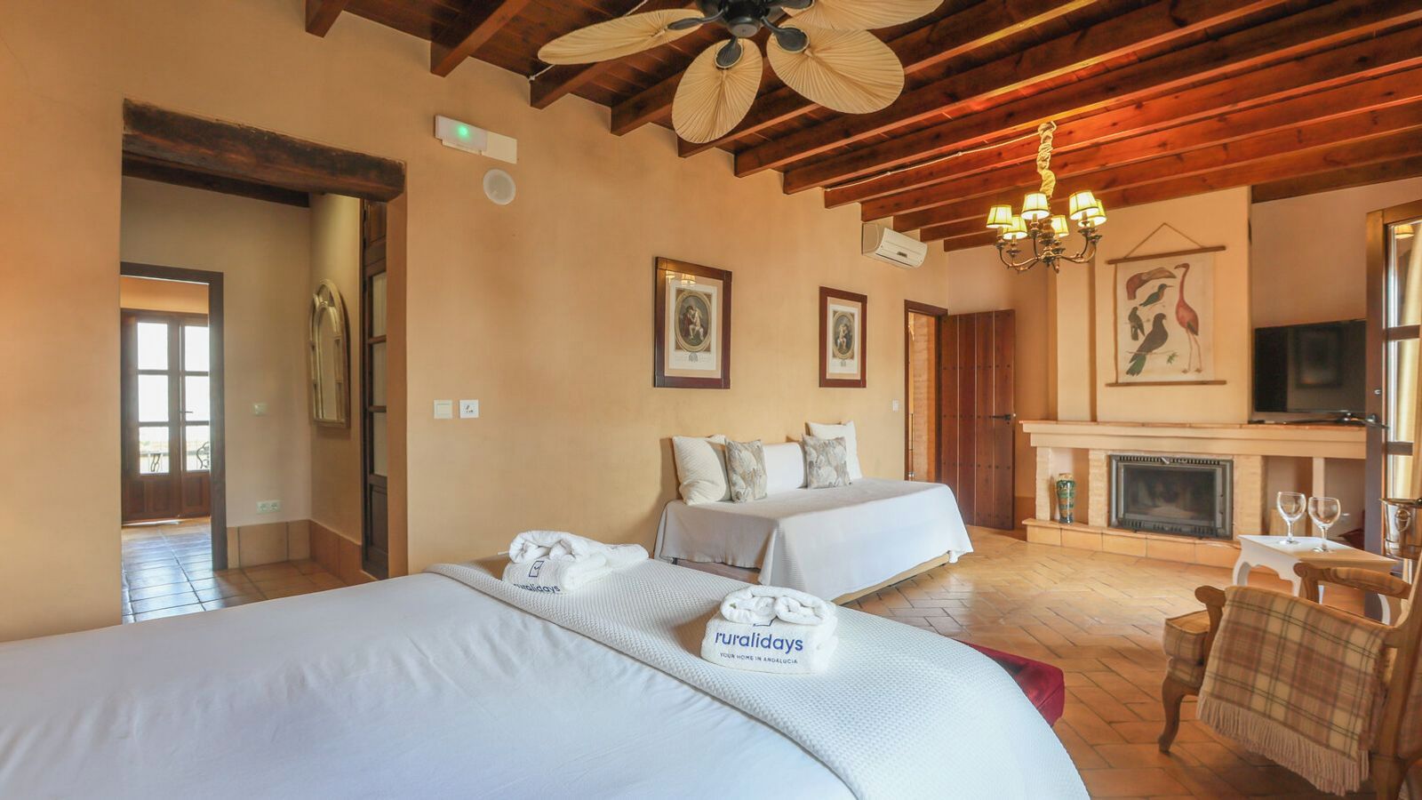 Une chambre d’hôtel avec deux lits, une cheminée et un téléviseur.