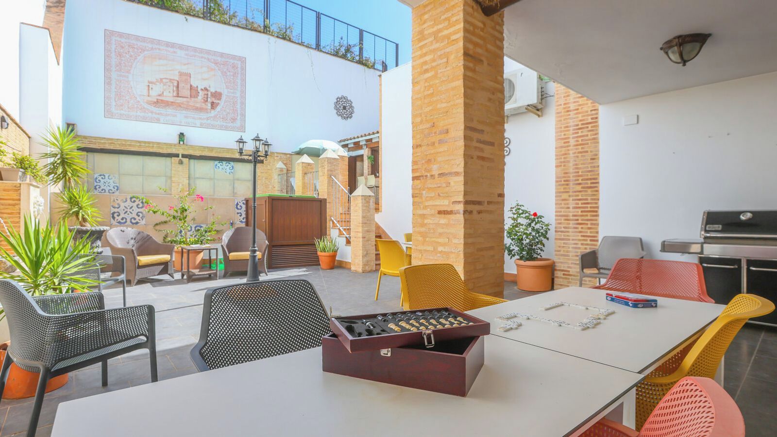 An outdoor patio area with seating, a barbecue grill, and a decorative wall.