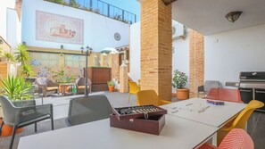 Ein Außenbereich mit Sitzgelegenheiten, einem Grill und einer dekorativen Wand.