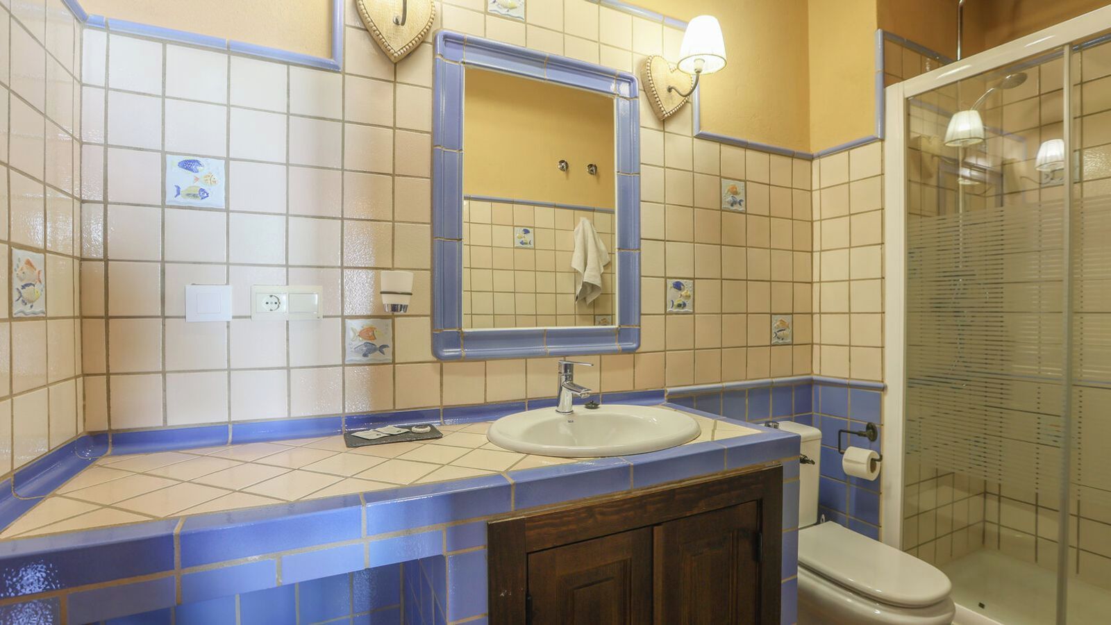 A bathroom with a sink, mirror, and toilet.