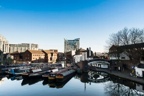 A canal with boats docked, a bridge, and buildings including a modern glass structure. - City Centre Gem | Balcony, 2 Baths & balcony (Birmingham)