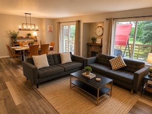A living room with two sofas, a coffee table, and a dining area with chairs and a table.