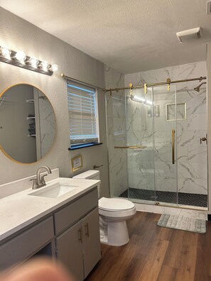 Een moderne badkamer met een wastafel, toilet en douchecabine.