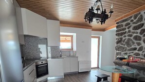 Eine moderne Küche mit Granit Arbeitsplatten, einem Einbauofen und einer Wand mit Steinverkleidung.