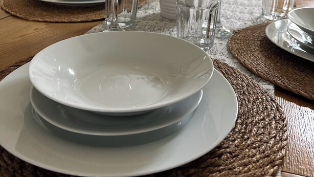 A dining table set with plates, glasses, and a potted plant. - Modern 3-Bed Home | Walk to Town & Metro | Sleeps 7 (Altrincham)