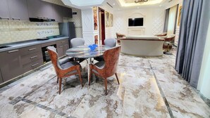 A modern interior with a dining area, kitchen, and living space. - Fountain Palace Hotel & Suites (Kampala)