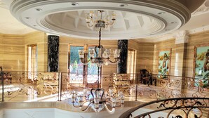 A grand interior with a high ceiling, ornate chandeliers, and a marble staircase. - Fountain Palace Hotel & Suites (Kampala)