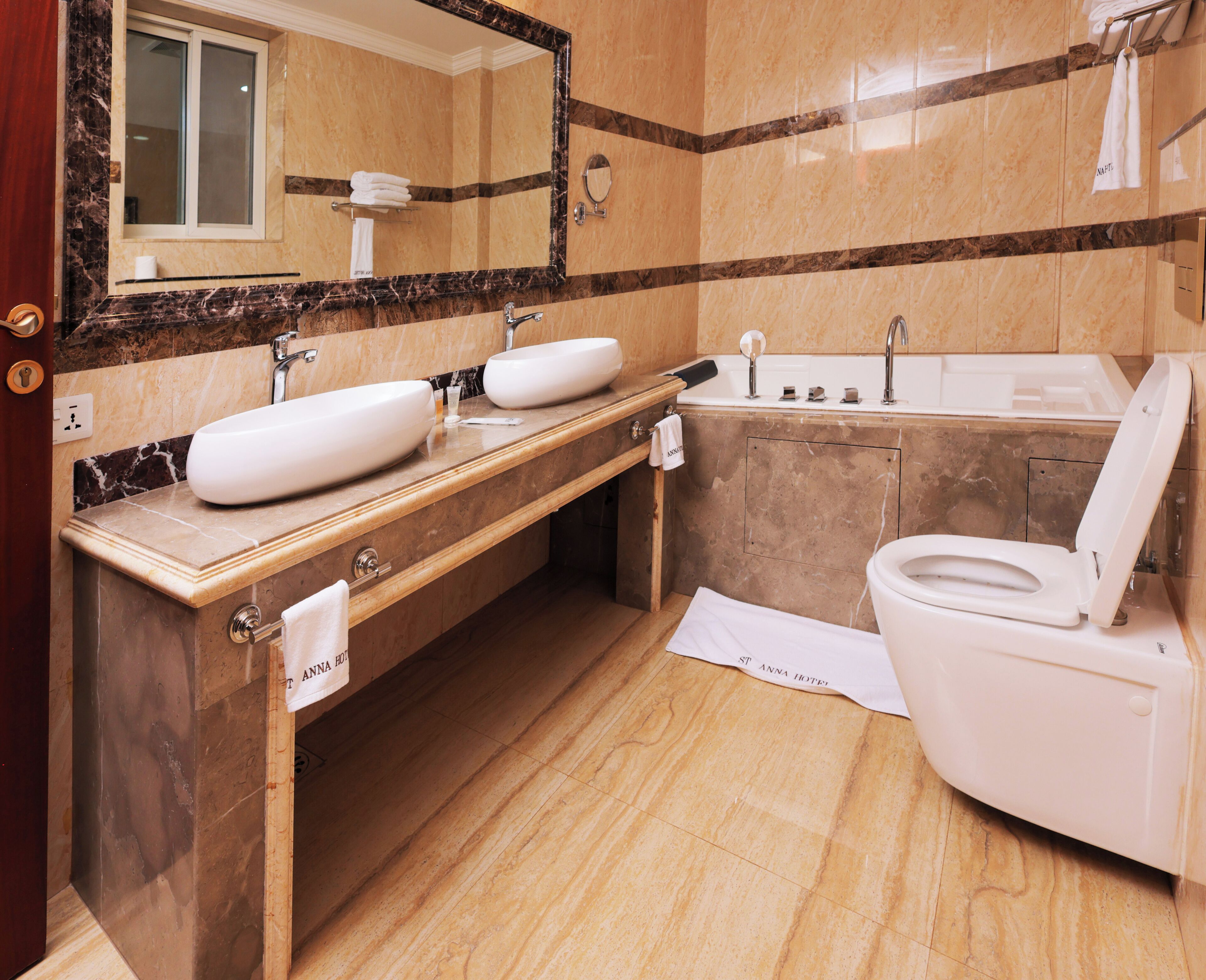 Un baño moderno con lavamanos doble, bañera y retrete.