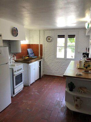 A compact kitchen with a stove, sink, and a window. - Le cactus - STE-MARIE-LA-MER (STE-MARIE-LA-MER)