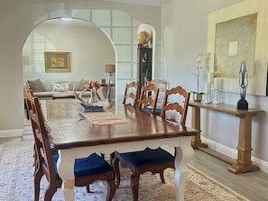 A dining room with a wooden table, chairs, a sofa, and a decorative globe. - The Gilbert Rustic Hideway (Gilbert)