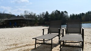 A beach with two chairs and a building in the background. - Lake-Front Family Home in Big Canoe (Jasper)