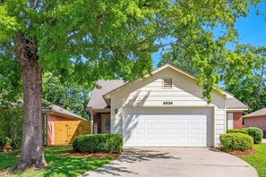 A single-story house with a white garage, a mailbox, and a well-maintained lawn. - Renovated Retreat w/ Game Room & Free Parking (Montgomery)