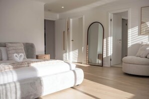 A modern bedroom with a bed, a sofa, and a mirror. - Whitesands by Aryve | Robina (Robina)