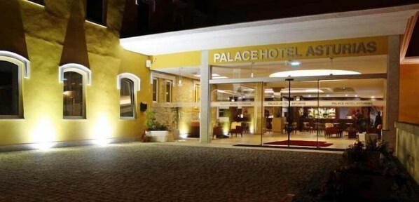 En hotelindgang med et skilt, der viser 'PALACE HOTEL ASTURIAS'.