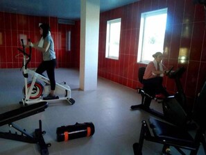 Ett gym med motionscyklar och en viktbänk.