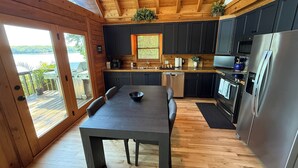 Una cocina moderna con mesa de comedor, electrodomésticos integrados y vistas al exterior.