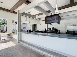 A modern kitchen with pendant lighting, a counter, and a view of the outdoors. - Modern Resort Condo Minutes to Disney (Kissimmee)