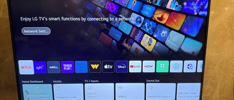 A television screen displaying a smart TV interface with various streaming services and connectivity options.