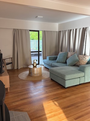 A living room with a sofa, a coffee table, and a TV stand.