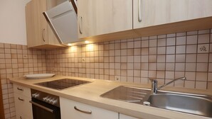 A kitchen with a countertop, sink, oven, and cabinets. - Beautiful Ground Floor Apartment with Dreiwelten Card and Terrace near Solemar (Bad Dürrheim)