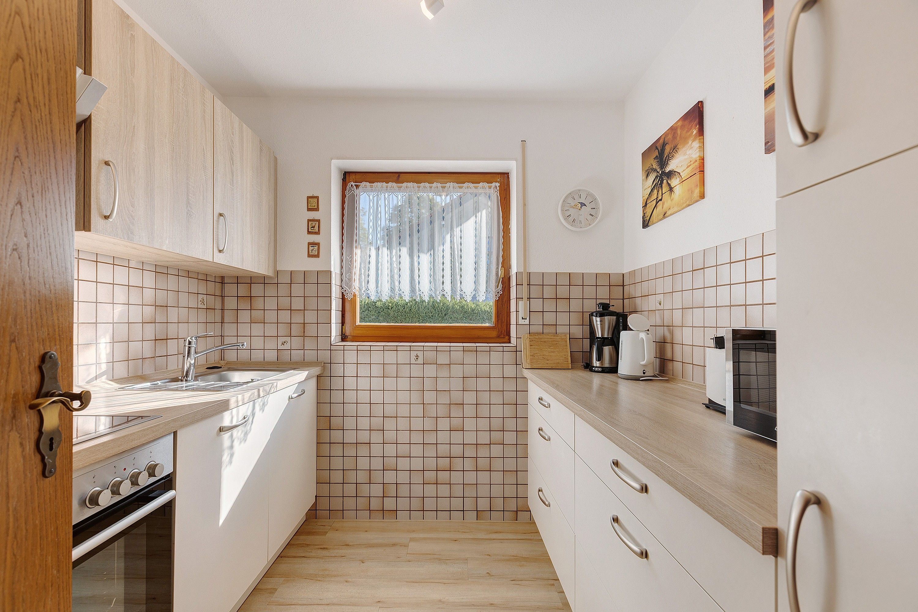 A kitchen with a window, tiled backsplash, wooden cabinets, and a stove.