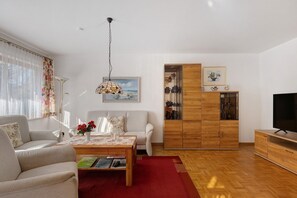 A living room with a sofa, coffee table, and a TV stand. - Beautiful Ground Floor Apartment with Dreiwelten Card and Terrace near Solemar (Bad Dürrheim)