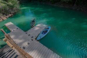 A wooden dock with a kayak and a paddleboard.