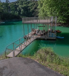 A dock extending over a body of water with a small boat docked nearby.