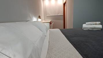 Ein Hotelzimmer mit Bett, Nachttisch, Spiegel und Handtuchhalter.
