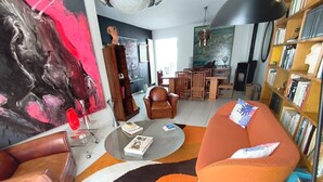 Een moderne woonkamer met een bank, salontafel en boekenkast.