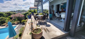 A modern outdoor patio with a pool, seating area, and a view of the surrounding landscape. - SAINT-JEAN DE LUZ, SAINTE-BARBE VILLA 3 PIECES AVEC PISCINE (ST JEAN DE LUZ)