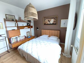 A bedroom with a bed, a bookshelf, a hanging light fixture, and two framed artworks on the wall. - SAINT-JEAN DE LUZ, SAINTE-BARBE VILLA 3 PIECES AVEC PISCINE (ST JEAN DE LUZ)