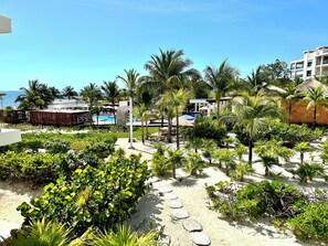 A resort with a pool, palm trees, and a beach area.