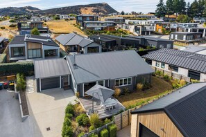 A modern residential area with contemporary houses, a well-maintained lawn, and a clear sky. - Farrant Drive Hideaway with Mountain Views (Wānaka)