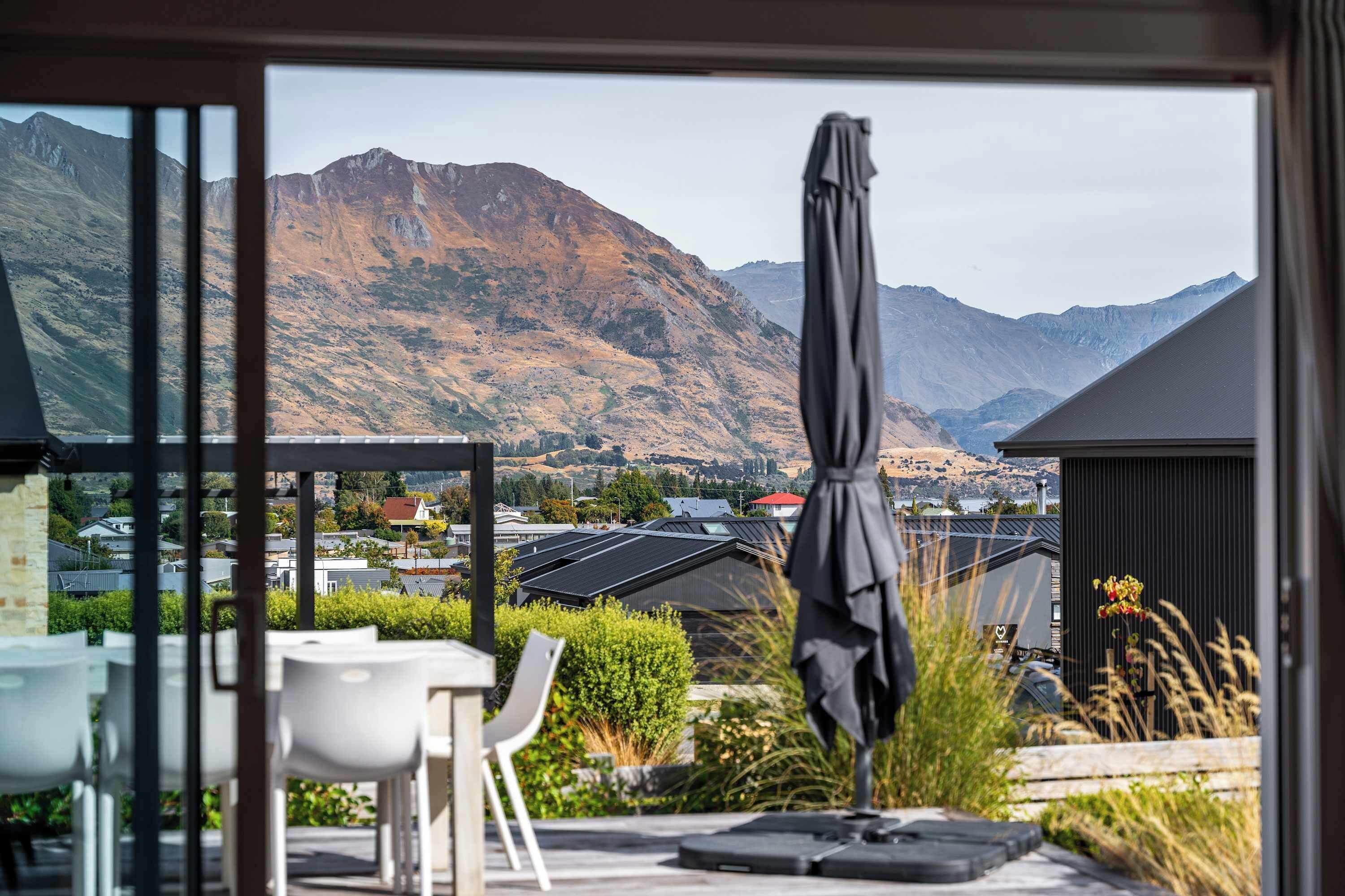 A patio with outdoor seating and a view of mountains.